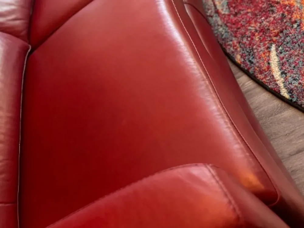 Close detail of a red leather sofa cushion and seam